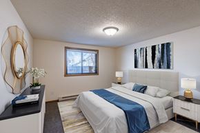Fargo townhouse for rent - a bedroom with a white bed and a blue blanket. Fargo, ND Berkshire Apartments