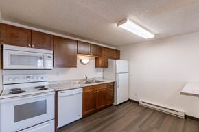 Fargo townhouse for rent - a kitchen with white appliances and wooden cabinets and a white refrigerator. Fargo, ND Berkshire Apartments