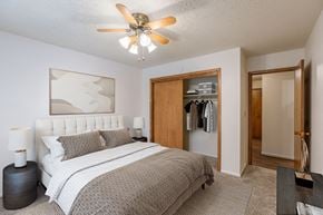 Fargo apartment for rent - a bedroom with a bed and a ceiling fan. Fargo, ND Betty Ann Apartments