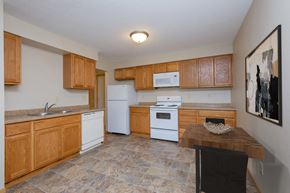 Fargo apartment for rent - a kitchen with white appliances and wooden cabinets. Fargo, ND Birchwood 2 Apartments