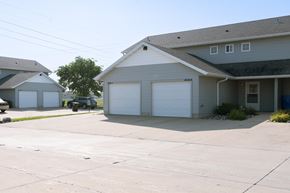 Fargo townhouse for rent - a white house with two garage doors and a driveway. Fargo, ND Bluestem Townhomes