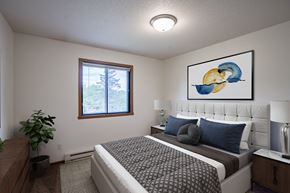 Fargo apartment for rent - a bedroom with a bed and a painting on the wall. Fargo, ND Briar Pointe Apartments