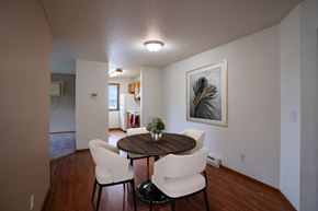 Fargo apartment for rent - a dining room area with a table and chairs and a living room in the background. Fargo, ND Briar Pointe Apartments