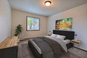 Fargo apartment for rent - A bedroom with a bed and a dresser. Fargo, ND Brownstone Apartments