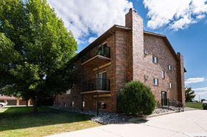 Fargo apartment for rent - Fargo, ND Cedars 2 Apartments. a red brick building with a stone chimney and a tree in front of it