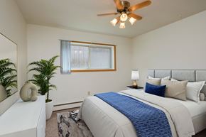 Fargo apartment for rent - a bedroom with a large bed and a ceiling fan. Fargo, ND Country Club Apartments.