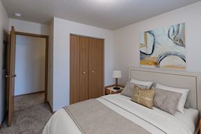 Fargo apartment for rent - a bedroom with a bed and a door to a closet. Fargo, ND Country Edge Apartments