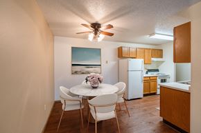 Fargo apartment for rent - a dining area with a table and chairs and a kitchen with a refrigerator. Fargo, ND Country Edge Apartments