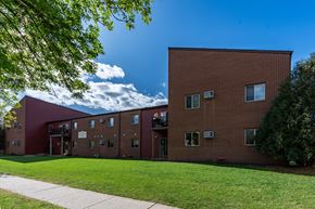 Fargo apartment for rent - an exterior view of a brick apartment building with green grass. Fargo, ND Crescent Park Apartments.