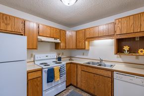Fargo apartment for rent - a kitchen with white appliances and wooden cabinets. Fargo, ND Crescent Park Apartments
