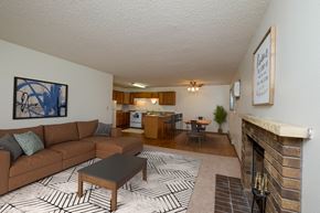 Fargo apartment for rent - Fargo, ND Dynasty Apartments. a living room with a fireplace and a kitchen in the background