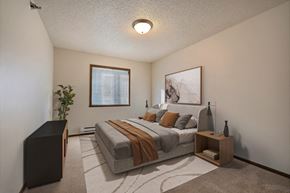 West Fargo apartment for rent - the view of a bedroom with a bed and a window. Fargo, ND Eagle Run Apartments