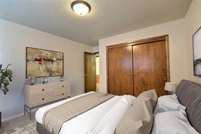 Fargo apartment for rent - a bedroom with a bed and a dresser. Fargo, ND Emerald Apartments