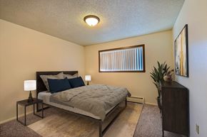 Fargo apartment for rent - a bedroom with a bed and a window. Fargo, ND Emerald Apartments