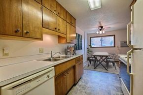 Fargo apartment for rent - A kitchen with wooden cabinets and a white dishwasher. Fargo, ND Emerald Apartments