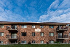 Fargo apartment for rent - a brick apartment building with balconies and a blue sky. Fargo, ND Emerald Apartments
