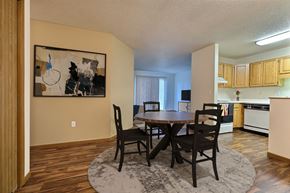 Fargo apartment for rent - Fargo, ND Flagstone Apartments. a dining area with a table and chairs and a kitchen in the background