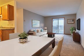 Fargo apartment for rent - a living room with a white table and chairs and a sliding glass door leading to a balcony at France, Fargo, ND