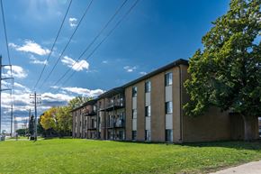 Fargo apartment for rent - a large brick apartment building with a green grass in front at France, North Dakota