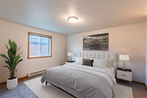 Fargo apartment for rent - a bedroom with a bed and a potted plant. Fargo, ND Galleria 3 Apartments