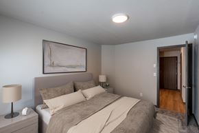 Fargo apartment for rent - a bedroom with a bed and a door to the hallway. Fargo, ND Granger Court Apartments