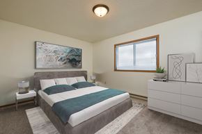 Fargo apartment for rent - Fargo, ND Hunters Run Apartments. A bedroom with a bed, dresser, and large window.