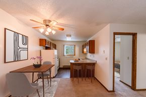 Fargo apartment for rent - a dining room and kitchen with a table and chairs and a ceiling fan. Fargo, ND Huntington Apartments
