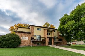 Fargo apartment for rent - An apartment building with a green yard and a cloudy sky.Fargo, ND Huntington Apartments.