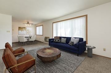 Fargo apartment for rent - a living room with a blue couch and chairs and a table