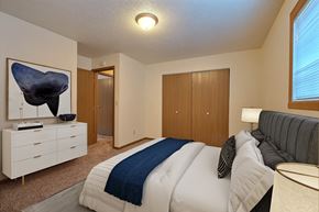 Fargo apartment for rent - a bedroom with a bed and a dresser. Fargo, ND Kennedy Apartments
