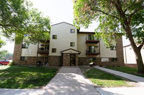 Fargo apartment for rent - An apartment building with a sidewalk and trees. Fargo, ND Kentwood Apartments