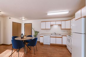 West Fargo apartment for rent - a kitchen with white appliances and a table with chairs. Fargo, ND Lake Crest Apartments
