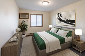 West Fargo apartment for rent - Fargo, ND Lake Crest Apartments. A bedroom with a large painting on the wall and a bed with a green blanket