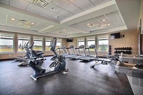 West Fargo apartment for rent - Fargo, ND Lake Crest Apartments. A room filled with lots of cardio equipment and a flat screen tv
