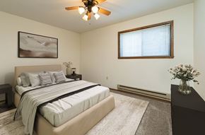 Fargo apartment for rent - a bedroom with a bed and a ceiling fan. Fargo, ND Maplewood Bend Apartments