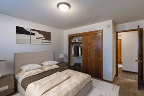 Fargo apartment for rent - a bedroom with a bed and a closet with a closet door. Fargo, ND Martha Alice Apartments