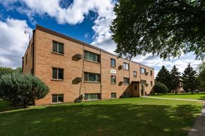 Fargo apartment for rent - a brick apartment building with green grass and trees. Fargo, ND Morningside Apartments