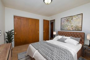 Fargo apartment for rent - a bedroom with a large bed and a painting on the wall. Fargo, ND North Manor Apartments