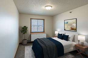 West Fargo apartment for rent - Fargo, ND Parkside Apartments. A bedroom with a large bed and a potted plant