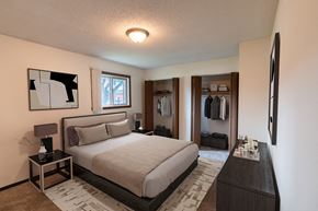 Fargo apartment for rent - a bedroom with a bed and a dresser and a closet. Fargo, ND Patricia Ann Apartments