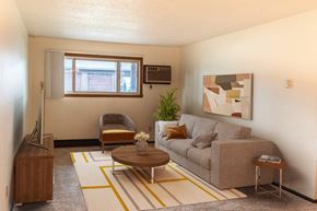 Fargo apartment for rent - the living room of a small apartment with a couch and a chair. Fargo, ND Patricia Ann Apartments