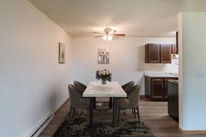 Fargo apartment for rent - a dining room with a table and chairs and a kitchen with a ceiling fan. Fargo, ND Patricia Ann Apartments