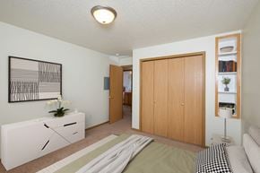 Fargo apartment for rent - A bedroom with a bed and a dresser and a closet. Fargo, ND Pinehurst Apartments