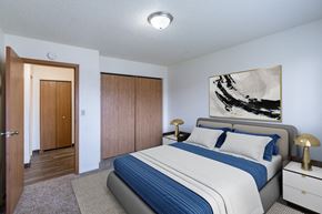 Fargo apartment for rent - a bedroom with a bed and a closet. Fargo, ND Place One Apartments