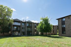 Fargo apartment for rent - An exterior view of a brick apartment building with green grass. Fargo, ND Place One Apartments.