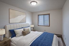 West Fargo apartment for rent - a bedroom with a large bed and a window. Fargo, ND Prairie Park Apartments