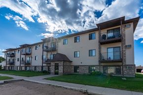 West Fargo apartment for rent - Fargo, ND Prairie Park Apartments. An apartment building with a cloudy sky in the background