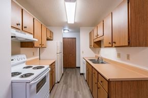 Fargo apartment for rent - a kitchen with stove refrigerator and sink. Fargo, ND Prairiewood Courts Apartments