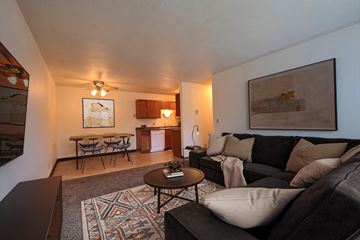 West Fargo apartment for rent - a living room with a couch and a table and a kitchen