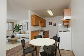 Fargo apartment for rent - a kitchen and dining room with a white table and chairs. Fargo, ND Sargent Apartments